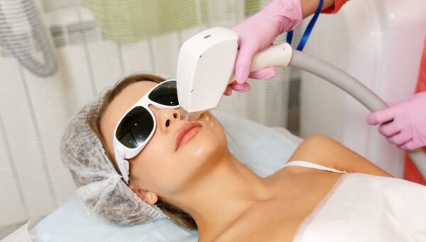 Expert performing laser hair removal cost in bangalore session on client’s skin.